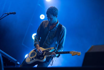 Man playing guitar at music concert