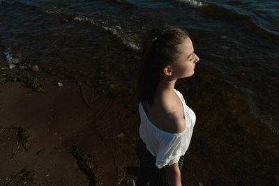 High angle view of young woman standing at beach