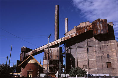 Low angle view of abandoned factory against sky