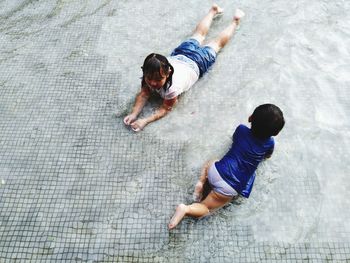 High angle view of siblings swimming in pool