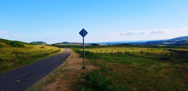 Road leading towards mountain against sky