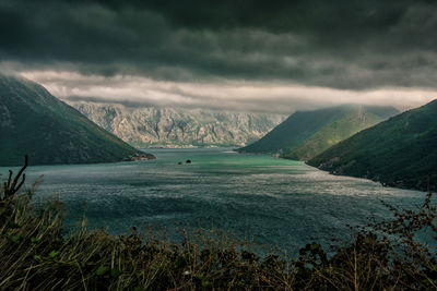 Scenic view of sea and mountains against sky