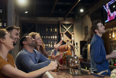 Happy friends watching soccer match at bar