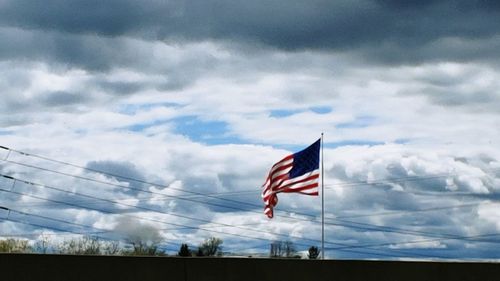 Low angle view of flag flags against sky