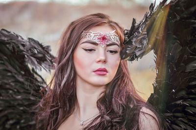 Close-up of beautiful young woman wearing angel costume