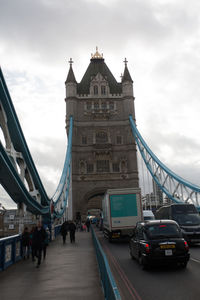 View of bridge in city against cloudy sky