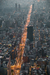 Aerial view of illuminated city street amidst buildings