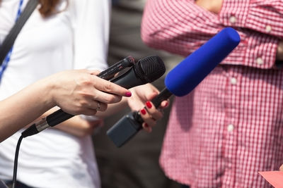Close-up of people holding microphone