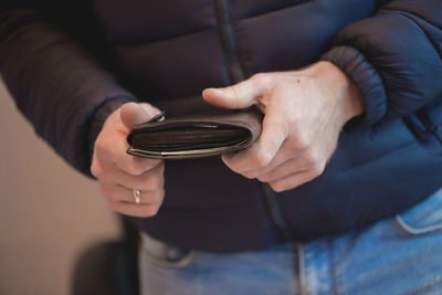 Midsection of man holding wallet