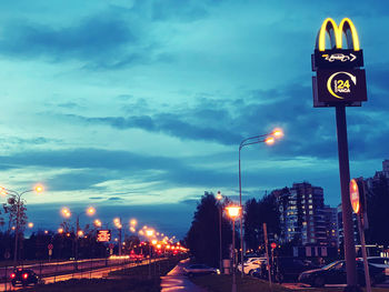 Illuminated street light against sky at night