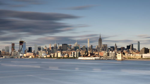 Modern buildings in city against cloudy sky