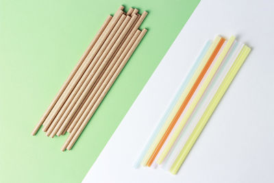 A bamboo and plastic straws for drinking on a colorful background, concept alternative
