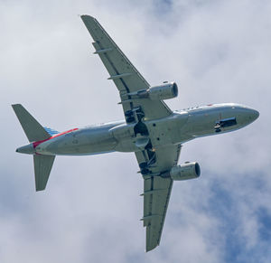 Low angle view of airplane flying against sky