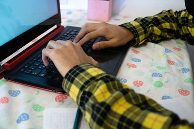 High angle view of child using laptop on table at home