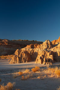 Scenic view of desert landscape rocks formations against clear blue sky