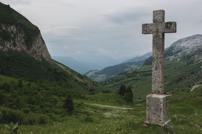 Cross on mountain against sky