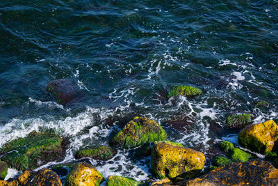 High angle view of sea water flowing through rocks