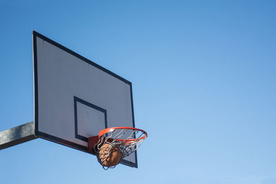 Low angle view of basketball hoop against blue sky