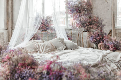 A bedroom in pastel colors in boho style. the room is decorated with lilac gypsophila flowers