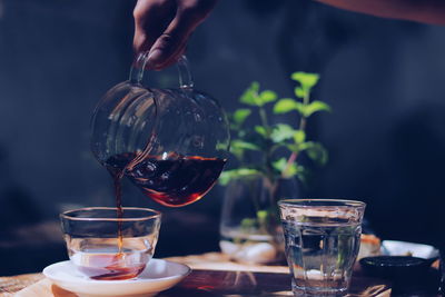 Midsection of woman holding drink on table