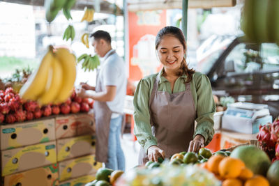 Portrait of smiling young woman standing in market