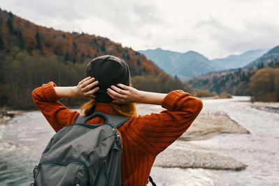 Full length of woman standing on mountain against sky