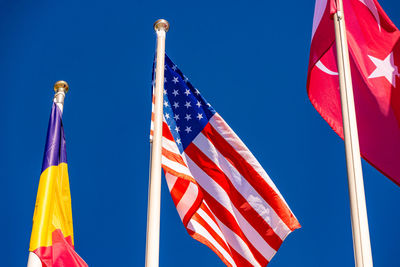 Low angle view of flag flags against blue sky