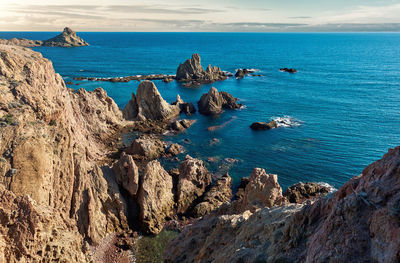Scenic view of rock formations by sea at cabo de gata-nijar natural park during sunset