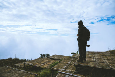 Man standing on built structure against sky