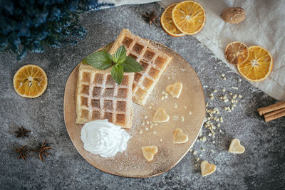 High angle view of waffles with oranges slices on table