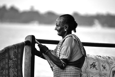 Young woman standing against sky