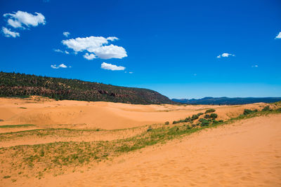 Scenic view of desert against blue sky