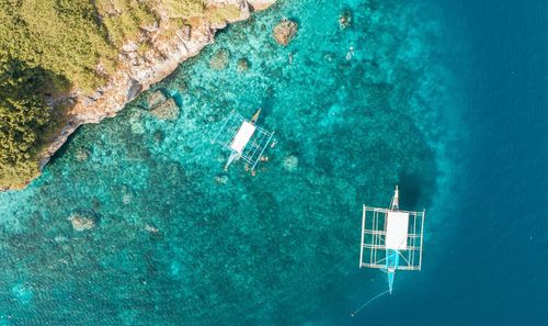 Aerial view of outriggers sailing in sea