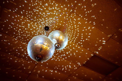 Low angle view of illuminated lighting equipment hanging on ceiling