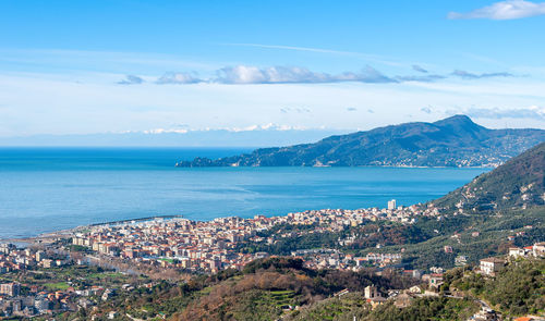 High angle view of townscape by sea against sky