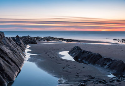 Scenic view of beach against sky during sunset