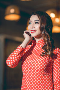 Smiling beautiful young woman wearing red dress