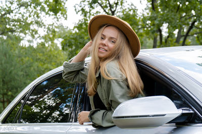 Young woman using mobile phone while sitting in car