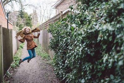 Full length of woman jumping over footpath