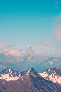 Airplane flying over mountains against sky