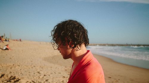 Portrait of woman on beach against clear sky