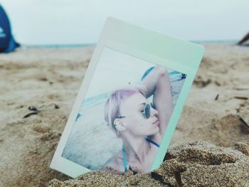 Close-up of young man reading book on beach