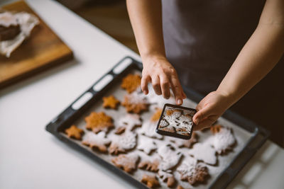 Woman takes photo on smartphone christmas gingerbread with powdered sugar.