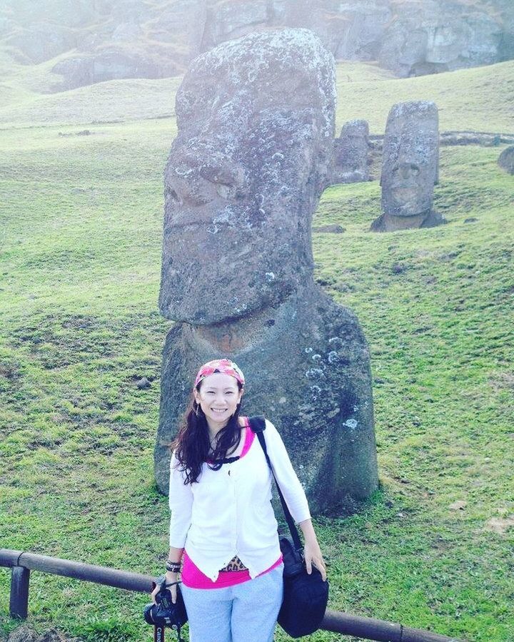 PORTRAIT OF YOUNG WOMAN STANDING BY LAND