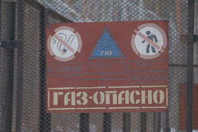 Close-up of warning sign on fence