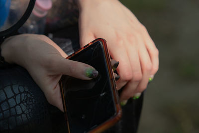 Midsection of woman holding smart phone