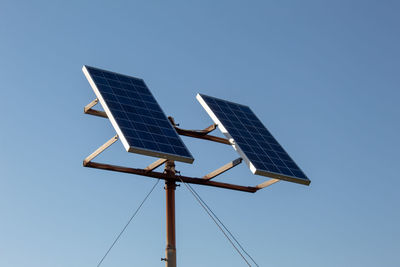 A closeup of solar panels with the background of a cloudless sky