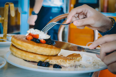 Close-up of person eating food in plate