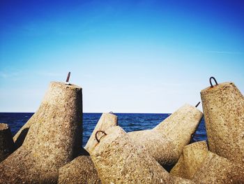  rock by sea against blue sky