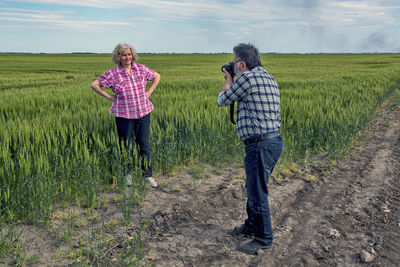 Rear view of two men standing on field